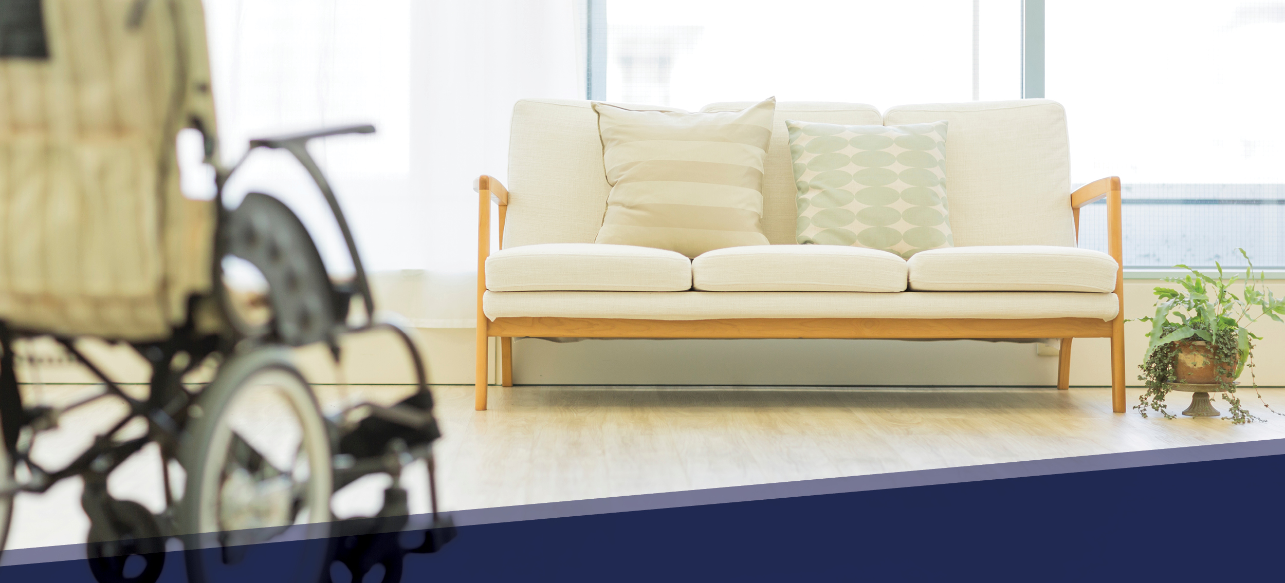 A wheelchair and a couch in a common area at a long-term care home.